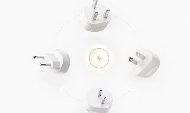 Adaptadores de enchufe internacionales colocados alrededor de un símbolo de corriente